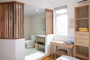 A modern bathroom with a wooden vanity, a toilet, and a shower area. - Vrbo Property (Port Louis)