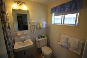 Een badkamer met een wastafel, toilet en een raam met uitzicht.