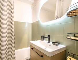 A bathroom with a white sink, a mirror, and a shower curtain. - Alpine Ski Apartment in Tignes for 4 (Saint-Sorlin-d'Arves)