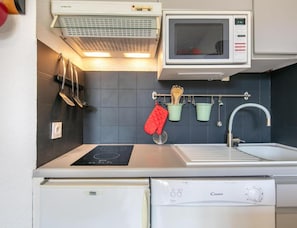 A compact kitchen with a microwave, stove, sink, and dishwasher. - Alpine Ski Apartment in Tignes for 4 (Saint-Sorlin-d'Arves)