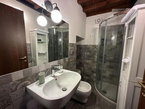 A bathroom with a white sink, a glass shower enclosure, and a toilet. - B and B Al Cardinale (Viterbo)