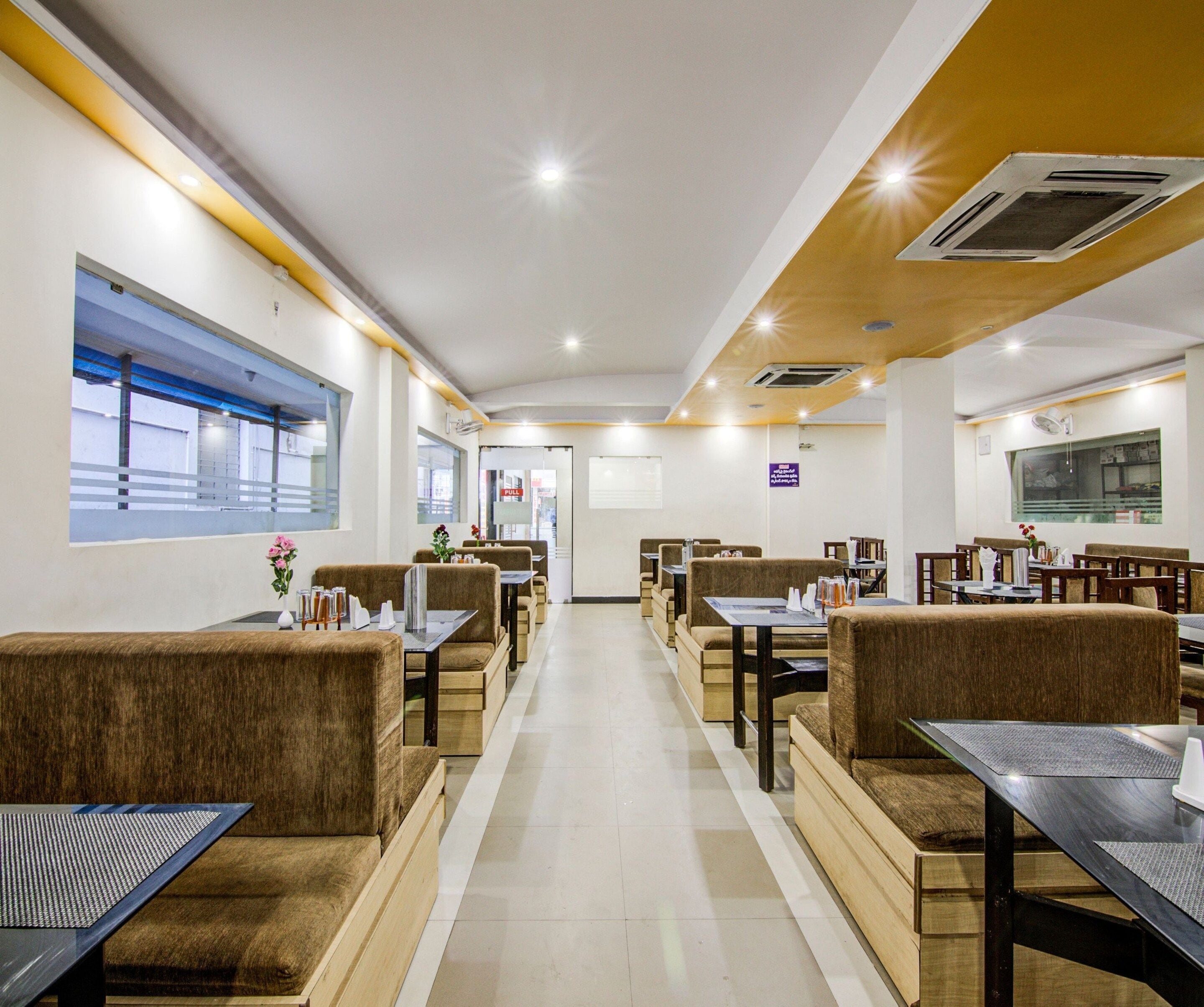 A restaurant with booths and tables, a tiled floor, and a view through the window.