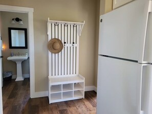 A kitchen with a white refrigerator, a white bench with storage, a sink, and a mirror. - Monkey Tree Farmhouse Cozy Retreat on Olympic DT (Sequim)