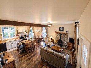 Un salón espacioso con chimenea, una mesa de comedor y una cocina equipada con electrodomésticos modernos.