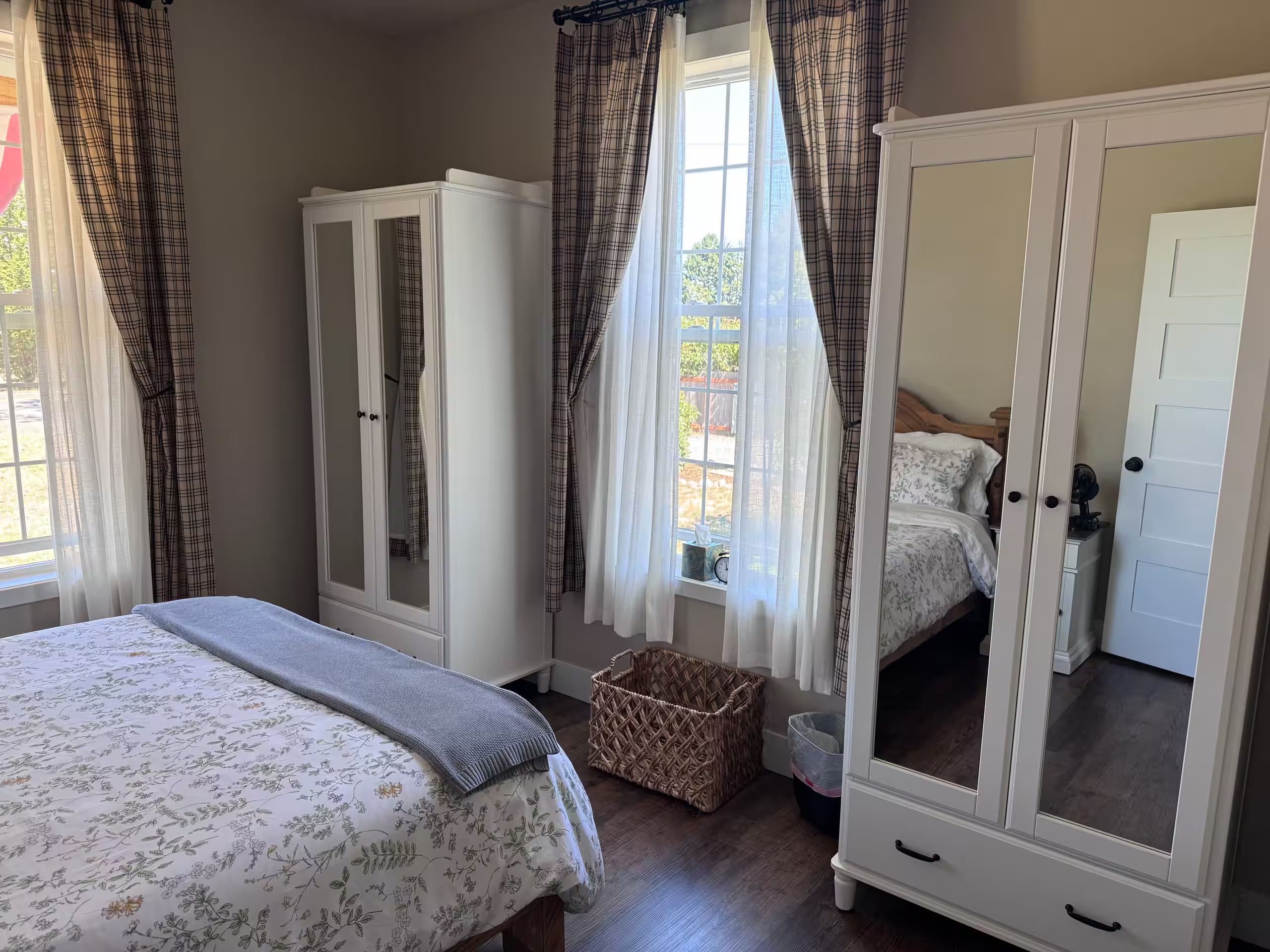 A bedroom with a bed, wardrobe, and a mirror cabinet.