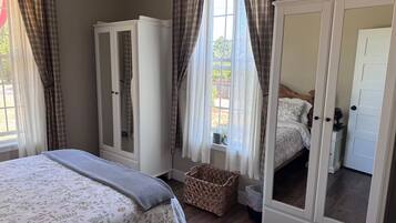A bedroom with a bed, wardrobe, and a mirror cabinet.