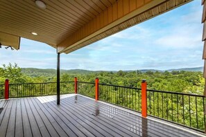 A wooden deck with a view of a forested landscape. - Top of the World Hot Springs (Hot Springs)