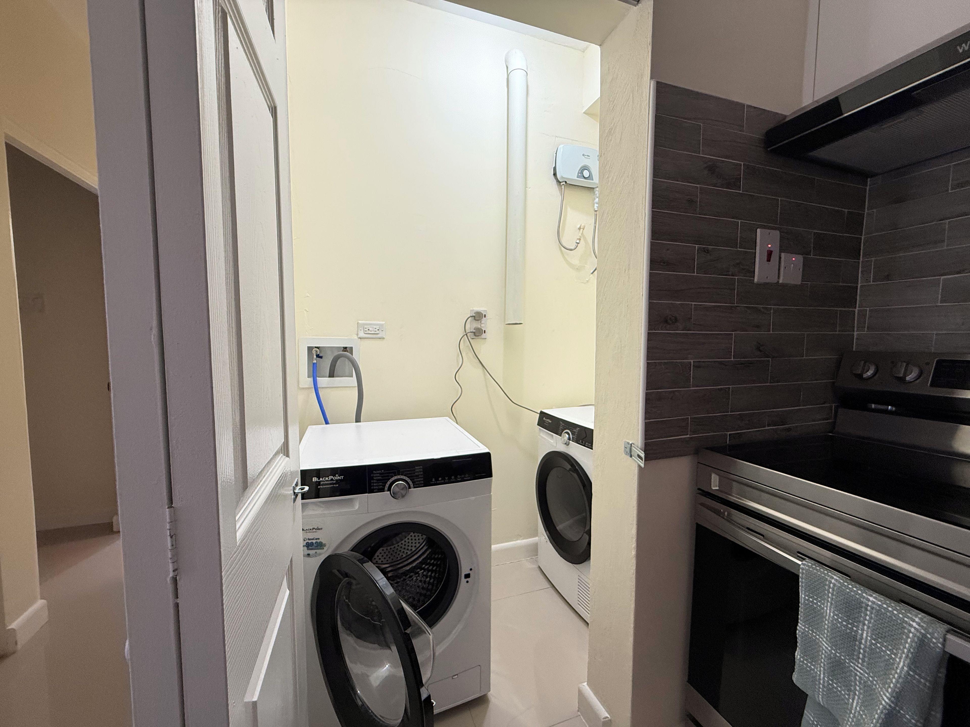 A compact laundry area with a washing machine, a dryer, and a built-in oven.