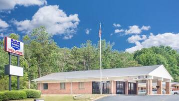 A Knights Inn & Suites with a clear sky and a flagpole with an American flag.