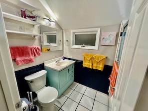 Een badkamer met toilet, wastafel, spiegel en handdoekhouders.