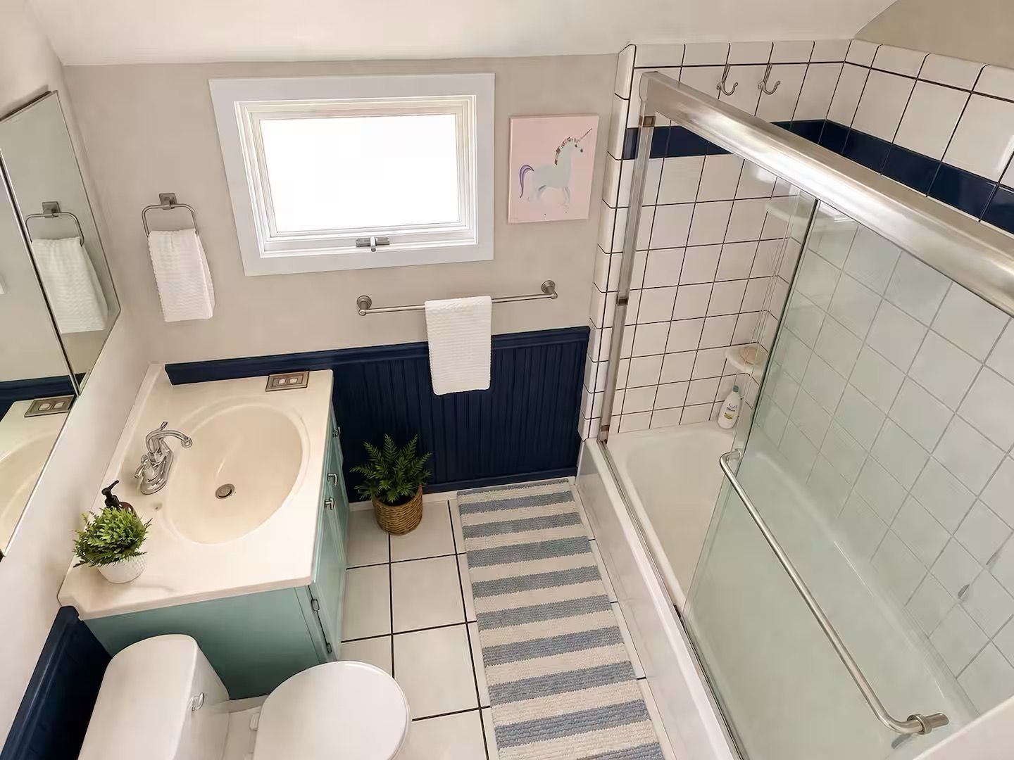 Une salle de bain comprenant un lavabo, des toilettes et un espace douche.