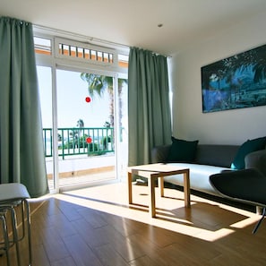 Una sala de estar moderna con un sofá, una mesa de centro y un cuadro en la pared.