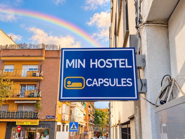 A hostel sign with a bed icon and the text 'MIN HOSTEL CAPSULES'.