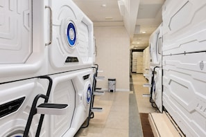 Un pasillo con filas de habitaciones blancas de diseño futurista, todas con un estilo y distribución similares.