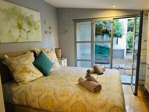 A bedroom with a bed, pillows, a nightstand, and a window with a view of the outside. - Luxury beach front 3-bedroom Villa/apartment Cannes Palm Beach (Cannes)