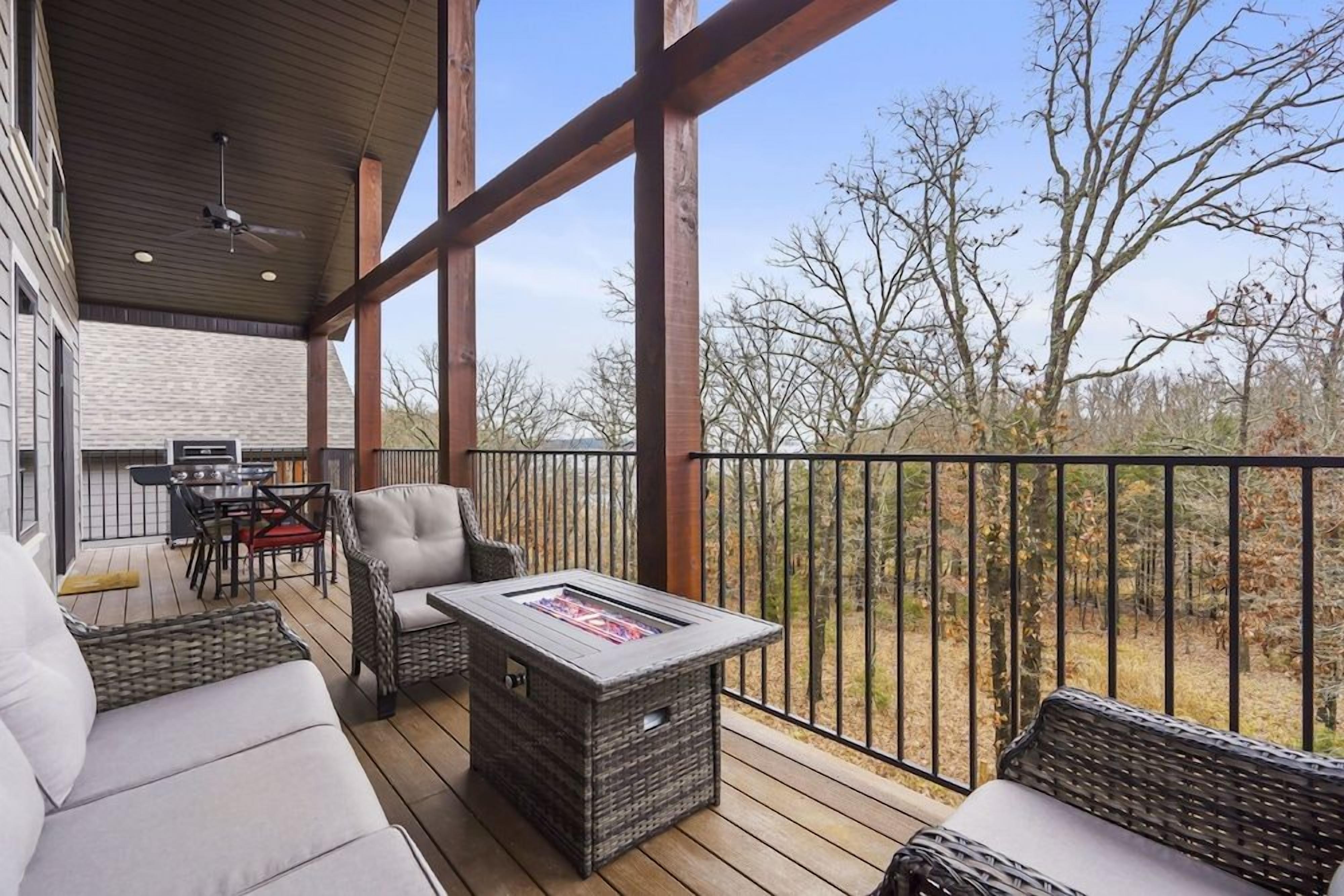 A covered outdoor deck with wicker furniture, a fire pit, and a dining area.