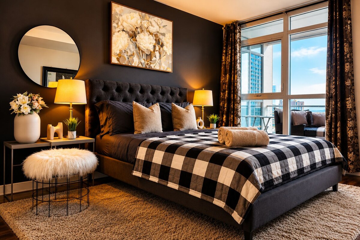 Een moderne slaapkamer met een groot bed, twee nachtkastjes, een ronde spiegel en uitzicht op de stad.