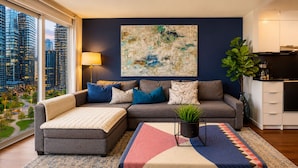 A modern living room with a sofa, a coffee table, and a city view. - The Hazelton Horizon Downtown (Toronto)