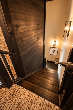 Eine Holztreppe mit einem strukturierten Teppich am Fuß.