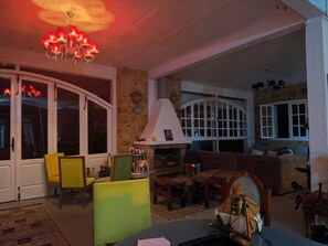 Una sala de estar acogedora con chimenea, asientos cómodos y una araña.