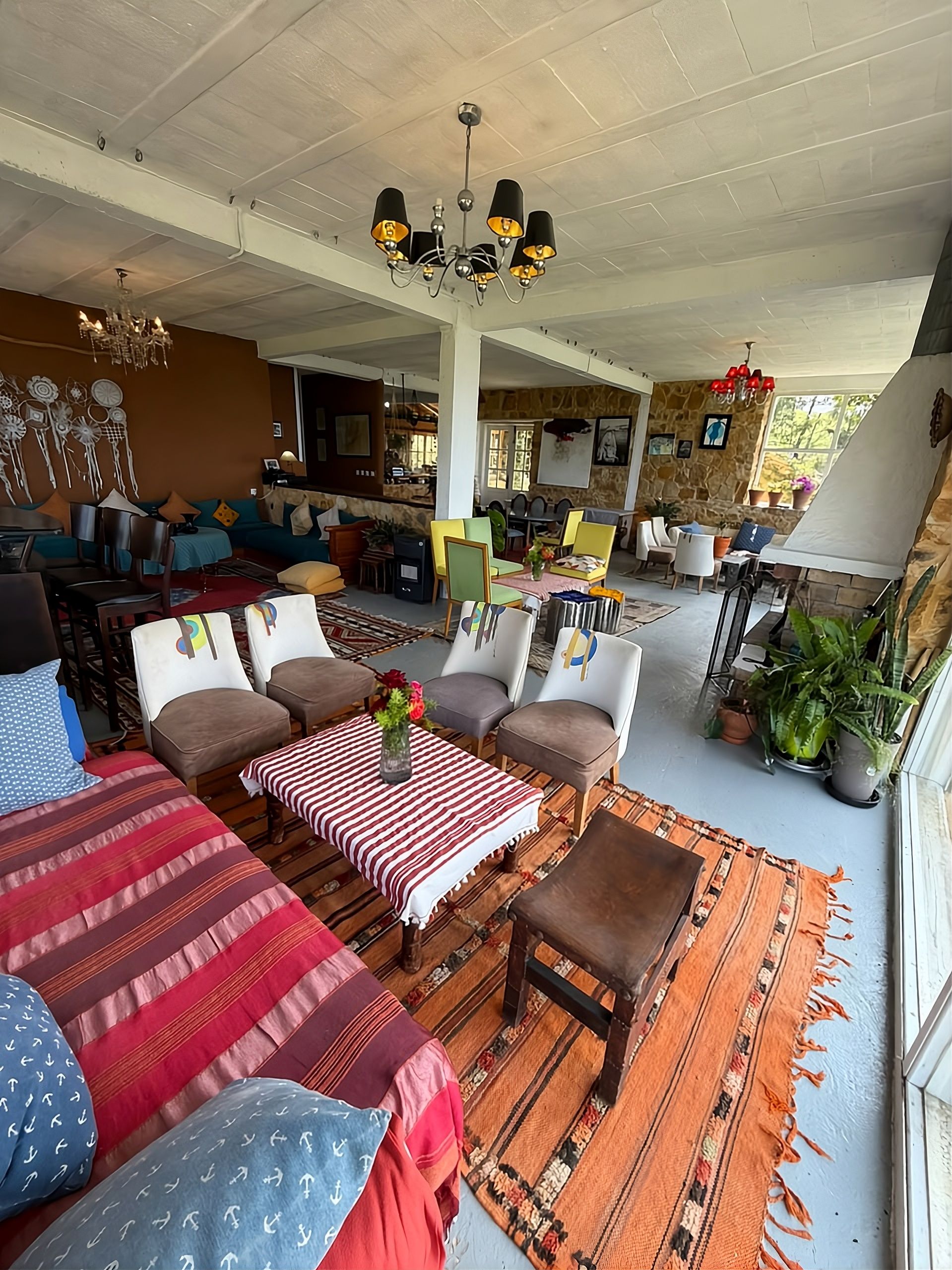Un vaste espace de vie comprenant une table à manger, plusieurs chaises et divers types de sièges.