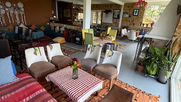 Un vaste espace de vie comprenant une table à manger, plusieurs chaises et divers types de sièges.