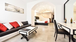 Ein modernes Hotelzimmer mit einer Couch, einem Esstisch und einem Bett.