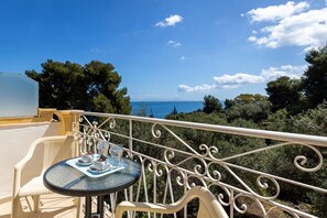 A balcony with a table set for two, overlooking a coastal landscape. - Alexandros Studios and Apartments (Paros)