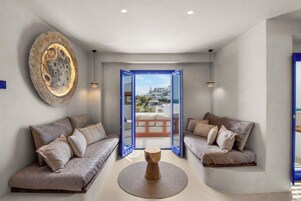 Un interior moderno con un conjunto de sofás, una mesa de centro de madera y una gran obra de arte en la pared.