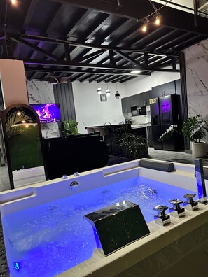 Une salle de bain moderne avec une grande baignoire, un lavabo et un miroir.
