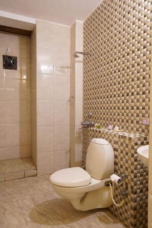 A bathroom with a toilet, a shower, and a sink. - OYO Rooms Trident Road (Udaipur)