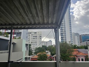 A view of a residential area with high-rise buildings, a covered balcony, and a clear sky. - Cozy 1-bedroom apartment in beautiful San Juan with AC (San Juan)