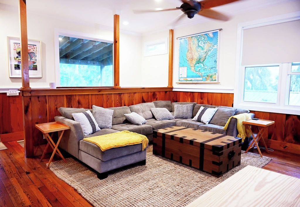 A cozy living room with a sectional sofa, a wooden coffee table, and a map on the wall.
