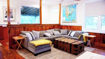 A cozy living room with a sectional sofa, a wooden coffee table, and a map on the wall.