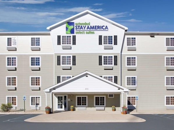 A multi-story hotel with a flat facade, a central entrance, and a parking lot. - Value Place Jackson, MS (Byram)