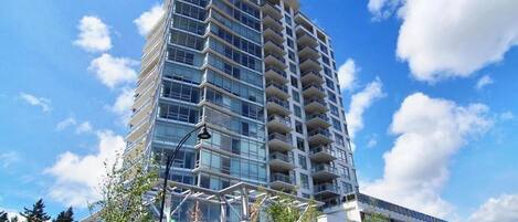 Un edificio de varios pisos con un diseño arquitectónico moderno, que cuenta con balcones en cada planta.