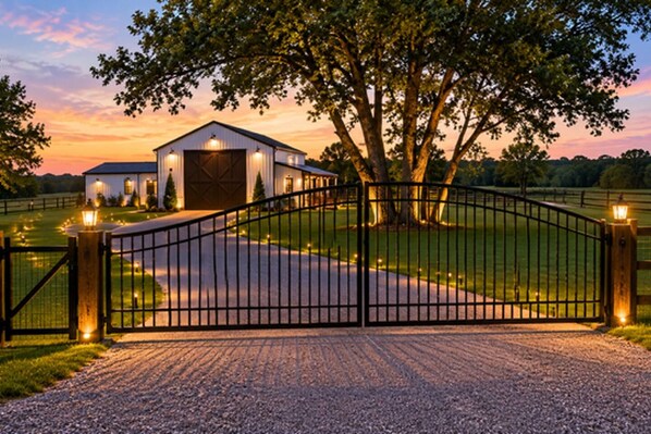 A gated property with a building and a large tree.