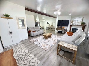 A spacious living room with a sofa, a coffee table, and a fireplace.