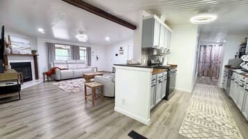 A spacious living area with a fireplace, a sofa, and a dining table.