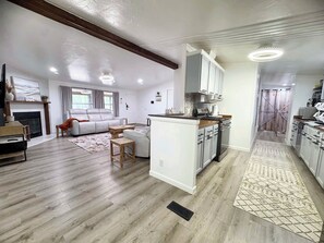 A spacious living area with a fireplace, a sofa, and a dining table.