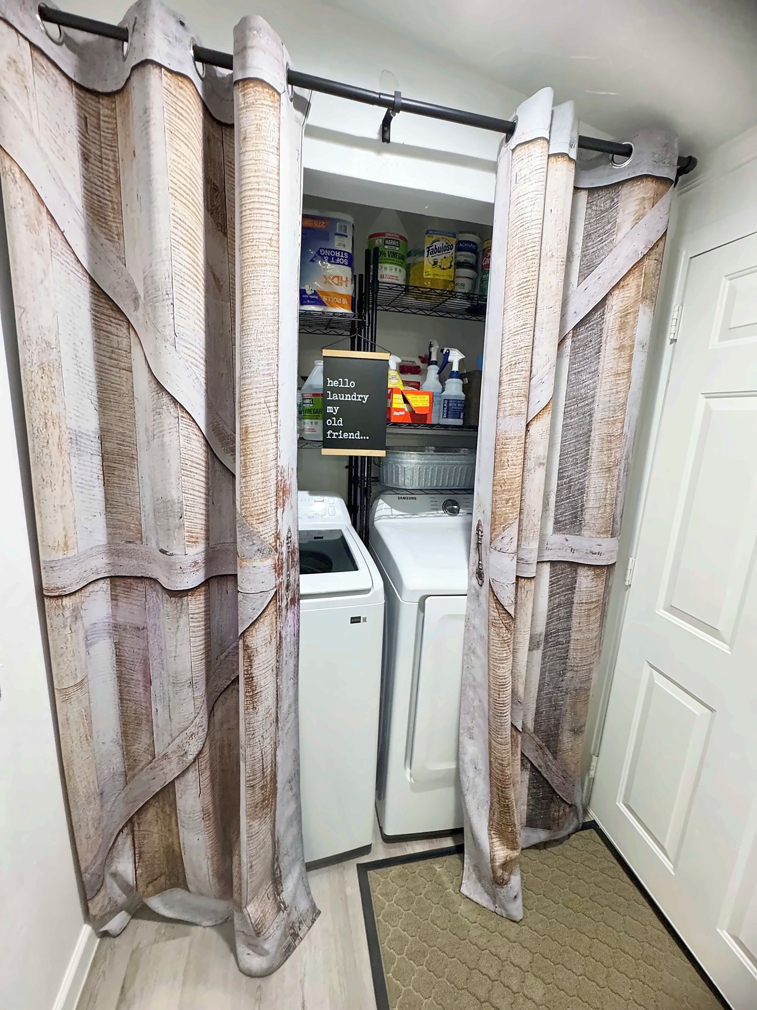 A laundry room with a washing machine, a drying rack, and a shelf with cleaning supplies.