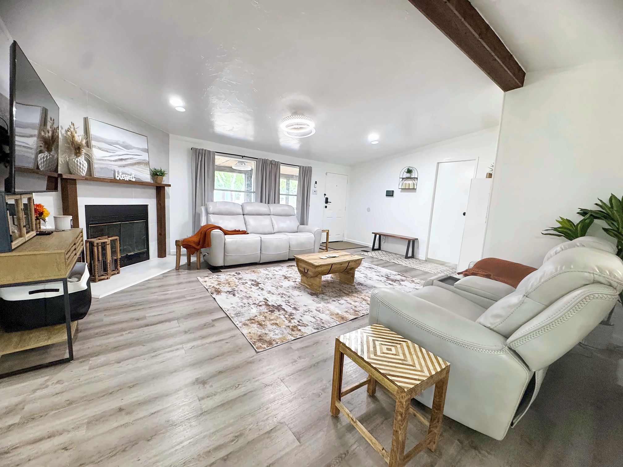 A spacious living room with a fireplace, a sofa, a coffee table, and a television.