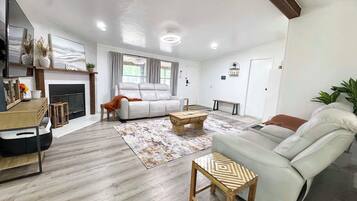A spacious living room with a fireplace, a sofa, a coffee table, and a television.