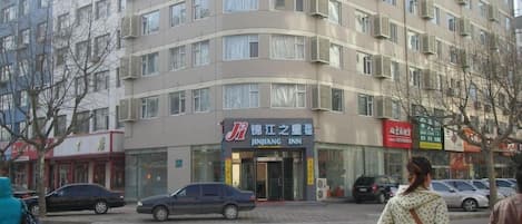 A multi-story building with a JINJANG INN hotel on the ground floor.