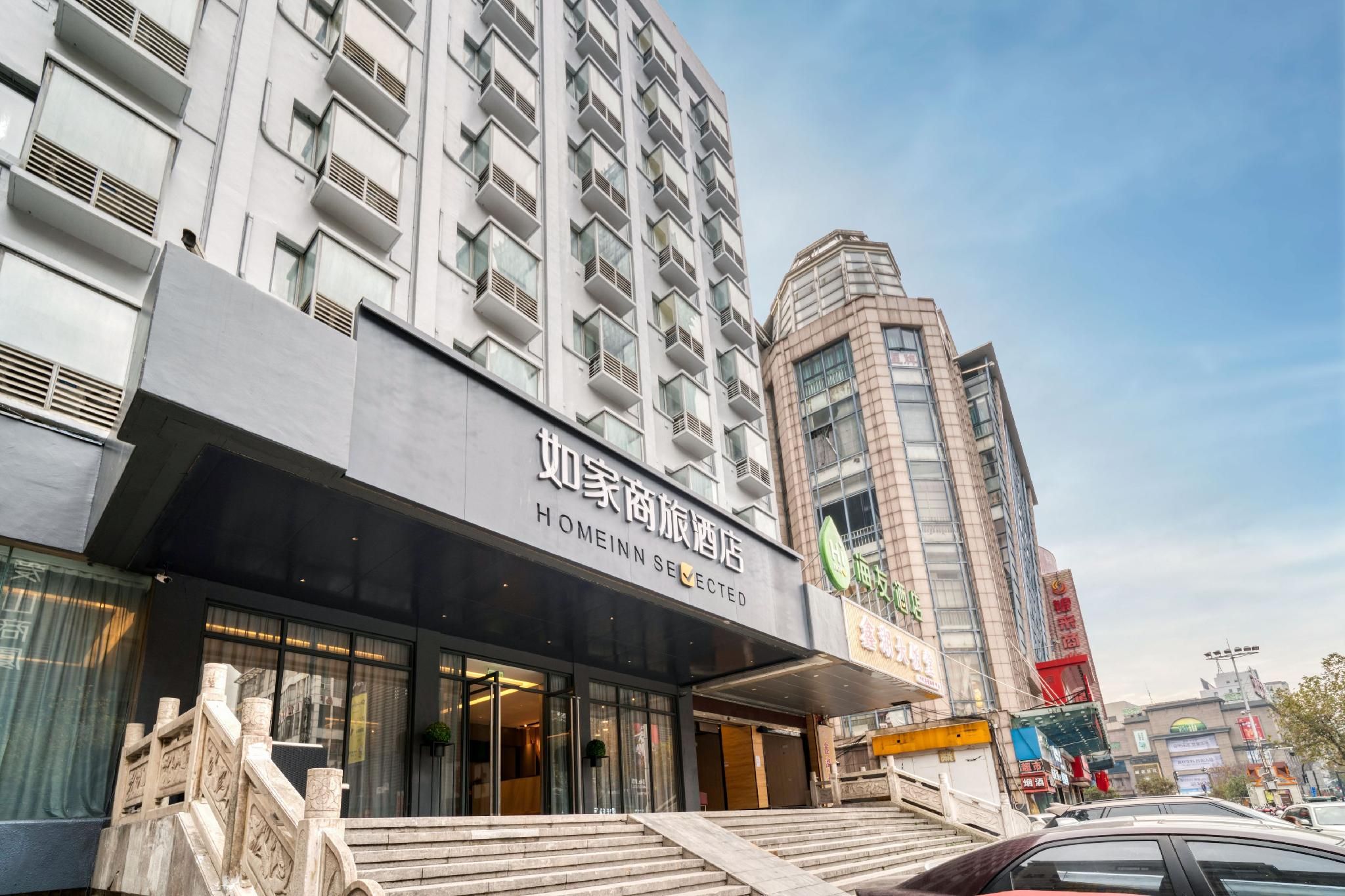 A hotel with a modern facade, large windows, and a visible staircase leading to the entrance.