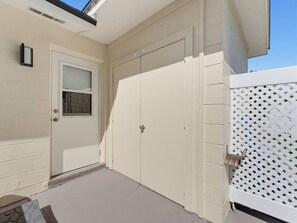 A house with a closed white door, a window with blinds, and a white fence with a lattice design. - Saltwater & Bubbles 5 | Indian Rocks Beach (Indian Rocks Beach)