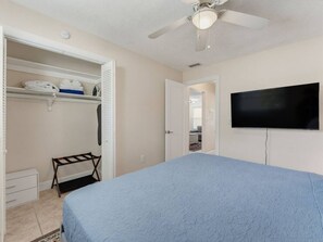 A bedroom with a bed, a TV, a closet, and a ceiling fan. - Saltwater & Bubbles 2 | Indian Rocks Beach (Indian Rocks Beach)