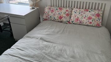Makuuhuone, jossa on sänky, työpöytä ja tuoli.