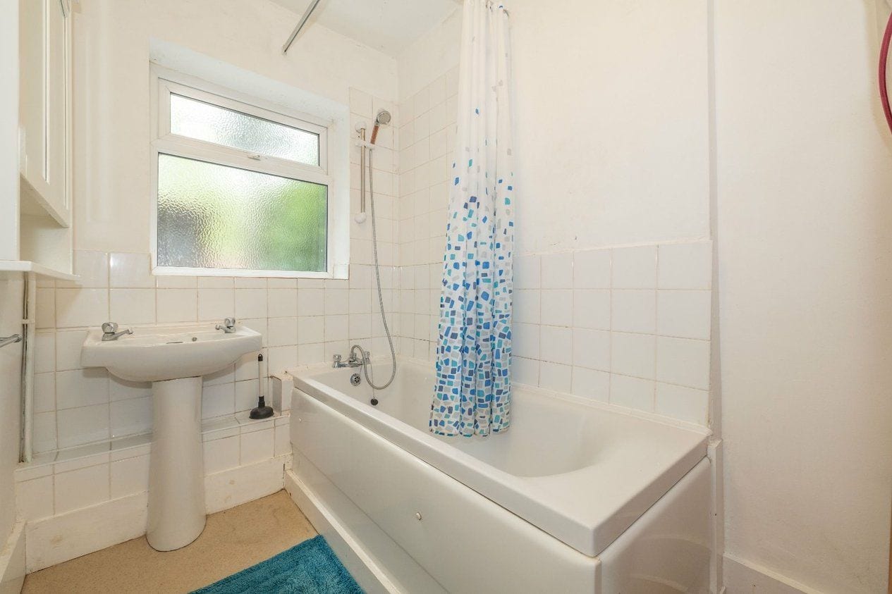 Ein Badezimmer mit einem weißen Waschbecken, einer Badewanne und einer Duschvorhang.