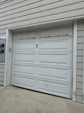 A white garage door with a simple design, a small mailbox, and a concrete driveway. - Home Away By the Beach 2! Beautiful 3-bedroom Newport Beach Upstairs Condo (Newport Beach)
